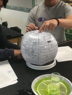 two people working on a model of the earth