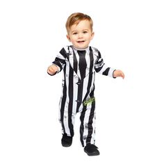 a little boy dressed in a referee outfit and holding his arms out to the side