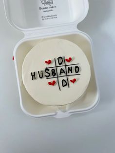 a cake in a box with the words husband written on it and hearts drawn on top