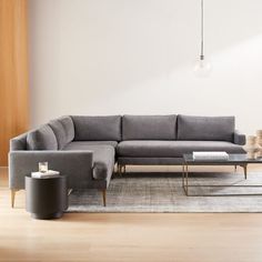 a living room with a sectional couch and coffee table on the floor in front of it