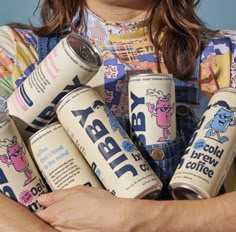 a woman holding six cans of baby milk