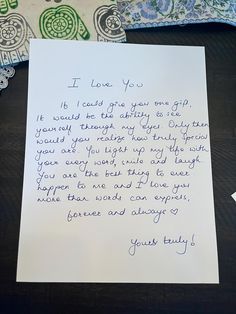 a handwritten letter from an unknown person on a table next to pillows and blankets