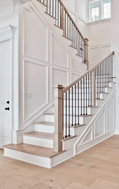 a staircase with white walls and wooden floors