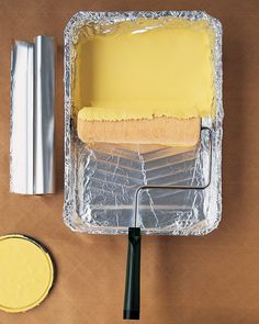 there is a cake in the pan with yellow icing on it and a rolling pin next to it