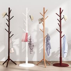 three coat racks with hats and scarves on them