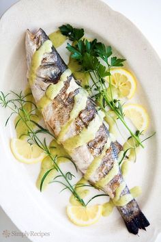 fish with lemon sauce and garnish on a white plate