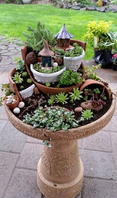 a potted planter filled with plants on top of a stone floor next to a lawn