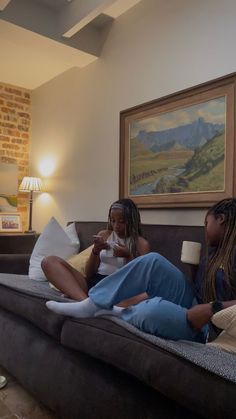 two women sitting on a couch in a living room