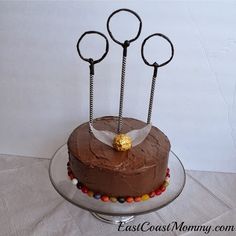 a chocolate cake with three metal scissors on top