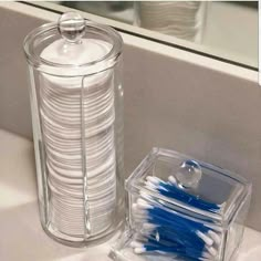 the toothbrushes are sitting next to the container on the sink