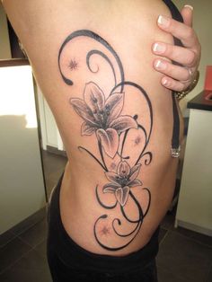 a woman's lower back tattoo with flowers on it