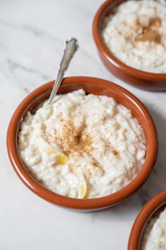 two orange bowls filled with oatmeal topped with cinnamon