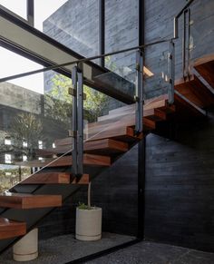 an indoor stair case with wooden handrails and concrete planters on the side