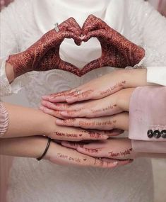 two brides holding their hands in the shape of a heart with words written on them