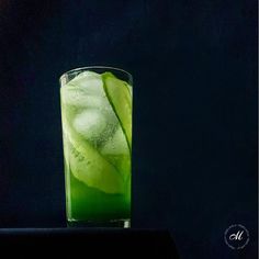 a tall glass filled with green liquid