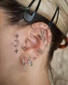 a woman with some piercings on her ear and behind her ear is a pair of scissors