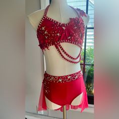 a woman's red and white bathing suit on display in front of a window