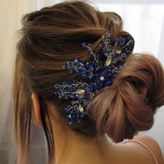 a woman wearing a hair comb with blue flowers on it