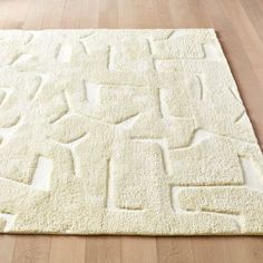 a white area rug on the floor in a room with wooden floors and hard wood floors