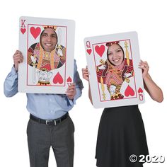 two people holding up playing cards in front of their faces