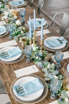 a wooden table topped with plates and place settings