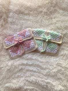 two crocheted bows are laying on a white blanket