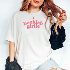 Calling all bookworms, book lovers, readers and booktroverts, we have a new name for you: BOOKISH GIRLIE Get the t-shirt and join the club. And don't worry, you won't have to talk to anybody. If you don't already own one of these Comfort Colors shirts, you're in for a treat! Super soft, top quality 100% cotton  Aesthetic vibes. Sure to be your new favorite tee. Exclusively designed by Parcel 23. Printed in the USA Contact me anytime via Etsy Messages with questions or custom requests. PLEASE NOT White Literary T-shirt With Letter Print, Bookish Cotton T-shirt With Letter Print, Bookish Crew Neck T-shirt With Letter Print, Bookish T-shirt With Funny Print, Bookish T-shirt With Funny Print For School, Bookish T-shirt With Funny Print And Short Sleeves, Bookish Short Sleeve T-shirt With Funny Text, Bookish T-shirt With Funny Text And Crew Neck, Bookish Crew Neck T-shirt With Funny Print