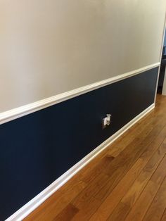 an empty room with wood flooring and blue paint on the walls, along with white trim