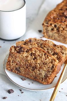 two slices of banana nut bread on a plate with a cup of coffee in the background