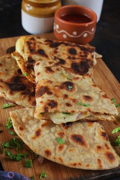 several flat breads stacked on top of each other with sauce in the back ground