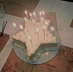 a birthday cake with white frosting and lit candles