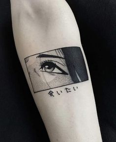 a woman's arm with an eye and japanese characters tattooed on the upper half of her arm