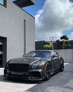 a grey sports car parked in front of a building