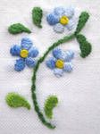 blue and yellow flowers on white fabric with green leaves