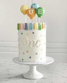 a birthday cake decorated with balloons and the number one