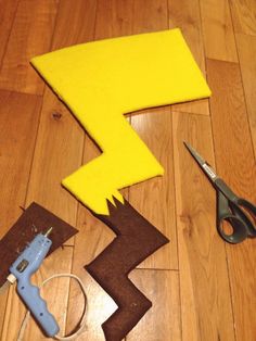 scissors, tape and felt pieces laid out on the floor to make a cutout