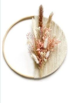 a headband with dried flowers and feathers on it, sitting on a white surface