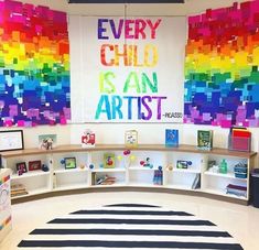 a classroom with colorful art on the wall and bookshelves in front of it