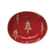 a red and gold christmas plate with trees on the rim, against a white background