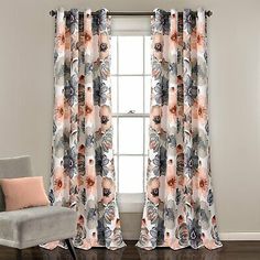 an orange and gray flowered curtain hanging on a window sill in front of a mirror