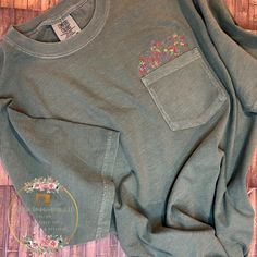 This pocket tee with embroidered wildflowers embroidered in a multi colored embroidery thread (as shown in the listing photo) OR choose your flowers to be embroidered in one solid color by choosing your thread color from the thread color chart in the listing photos.  This pocket tee with wildflowers is oh so cute, soft and comfy.  It will sure to be your go to t-shirt.  Embroidered on a Comfort Colors Tshirt available in a variety of colors and sizes.  6.1 oz 100% ringspun cotton and pre-shrunk, soft-washed and garment dyed fabric.  Sizes are unisex with a left chest pocket and embroidered flowers coming out of the top of the pocket.  If you need a size not listed please message me. Choose your shirt size (refer to sizing chart) and then in the personalization section let me know the color Green Spring T-shirt With Pockets, Green Pocket T-shirt For Spring, Green T-shirt With Pockets For Spring, Casual Tops With Multicolor Floral Embroidery, Casual Tops With Multicolor Floral Applique, Green Cotton T-shirt With Floral Embroidery, Fall Cotton T-shirt With Floral Embroidery, Grow In Grace, Floral Pocket