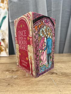 two books sitting on top of a wooden table next to each other, one with an image of a bride and groom