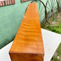 a piece of wood sitting on top of a white table next to a brick wall