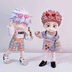 two figurines are standing next to each other on a white surface, one is holding a toothbrush and the other has pink hair