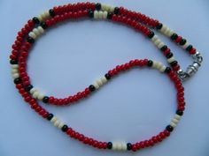 a red and white beaded necklace with black beads