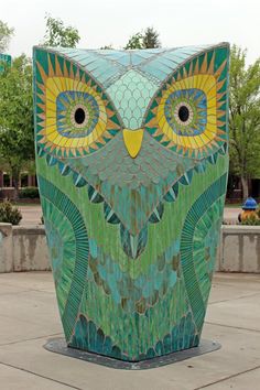 an owl statue sitting on top of a cement slab