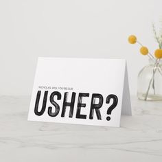 a card with the words usher on it next to a vase filled with flowers