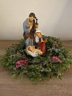 a nativity scene with figurines and greenery