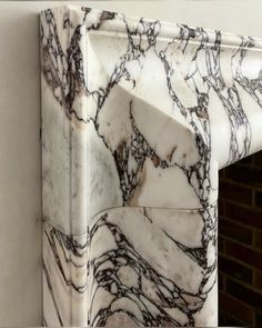 a marble fireplace mantel with black and white designs