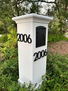 a white mailbox sitting in the middle of some bushes